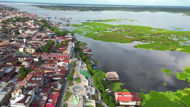 High-resolution aerial view of the riverfront boulevard in Iquitos featuring colorful historic buildings, vibrant urban streets, and a scenic promenade along the majestic Amazon River