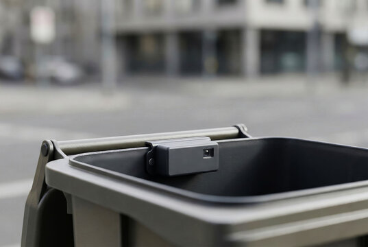 Smart waste management sensor mounted on a trash bin in the city
