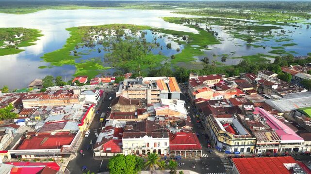 High-resolution aerial view of the riverfront boulevard in Iquitos featuring colorful historic buildings, vibrant urban streets, and a scenic promenade along the majestic Amazon River