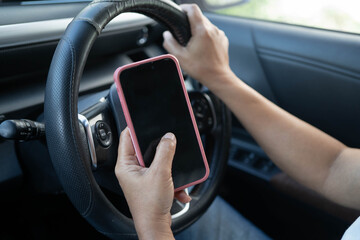 Naklejka premium Driver holding smartphone using map app for navigation in car.