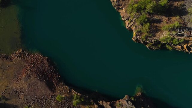 Screwdriver drone shot rising above lake Orajarvi, old copper mine in Finland