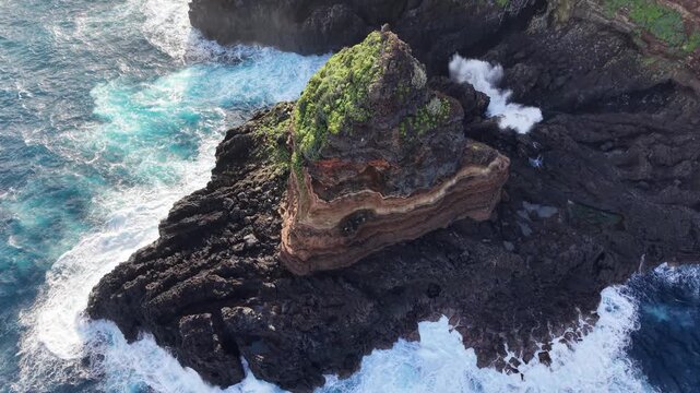 Stunning aerial footage showcasing the Roque de El Cagado. Turquoise ocean waves crashing against the volcanic cliffs of Santa Ursula in Tenerife
