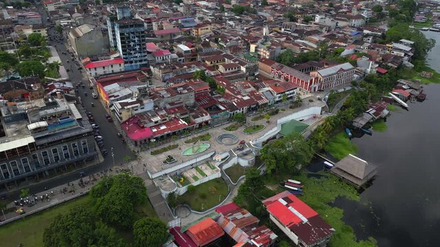 High-resolution aerial view of the riverfront boulevard in Iquitos featuring colorful historic buildings, vibrant urban streets, and a scenic promenade along the majestic Amazon River