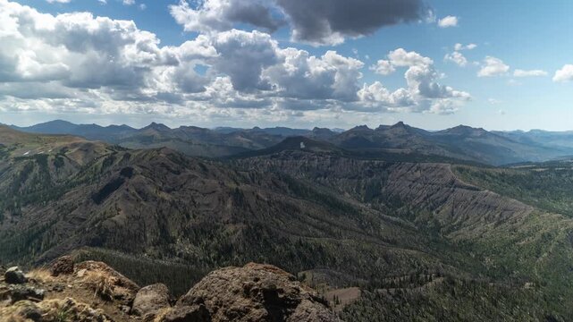Puffy clouds and their shadows moving over vast forested ridges and peaks, Absaroka Range, Montana, time lapse