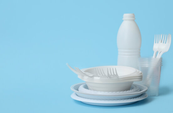 White plastic tableware on light blue background
