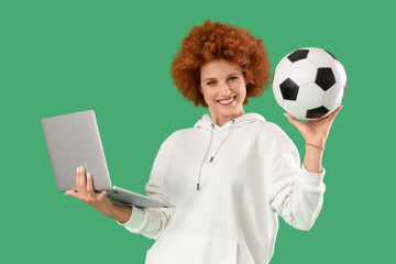 Beautiful young woman with laptop and soccer ball on green background. Sports bet concept