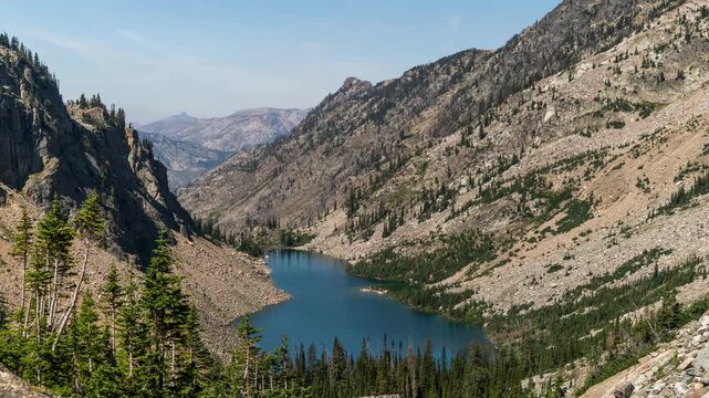 Clouds drifting over a blue glacial lake in a steep U-shaped mountain valley, Beartooth Mountains, Montana, time lapse