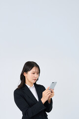 Fototapeta premium 困った表情でスマートフォンの画面を見るビジネスウーマン
