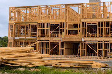Construction site frame of new building with wooden structure stacks of lumber