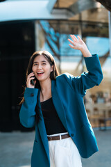 Fototapeta premium Happy young woman waving hand while on smartphone