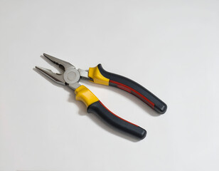 Fototapeta premium Metal pliers with yellow and black insulated grips, lying on white