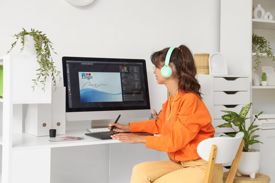 Female graphic designer in headphones working at home