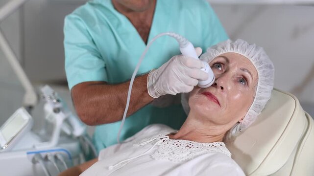 Experienced male doctor employs cold hammer whitening to administer cosmetic treatments, enhancing woman's natural beauty.