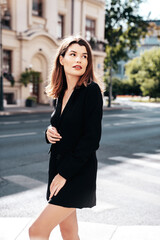 Fototapeta premium Portrait of young beautiful brunette woman wearing nice trendy suit black jacket clothes. Sexy smiling model posing in the street at sunny day. Fashionable female outdoors. Cheerful and happy