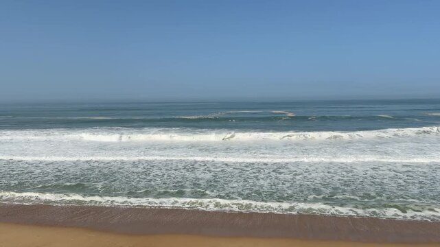 4K static shot of ocean waves crashing on a sandy beach with graffiti-covered concrete ruins. Cinematic coastal landscape in Labenne, Landes, France. High-quality nature background.