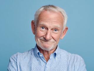 Obraz premium Smiling Senior Man Portrait on Blue Background, Wisdom and Life Experience Concept