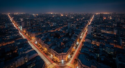 Obraz premium Dusk view of a sprawling metropolis, illuminated by streetlights, with long exposure car trails creating glowing streaks