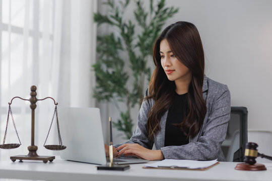 Young female lawyer working on laptop in office