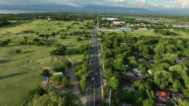 Aerial view of the scenic Bonuan Binloc highway surrounded by lush green trees and provincial landscape, Dagupan City, Pangasinan, Philippines
