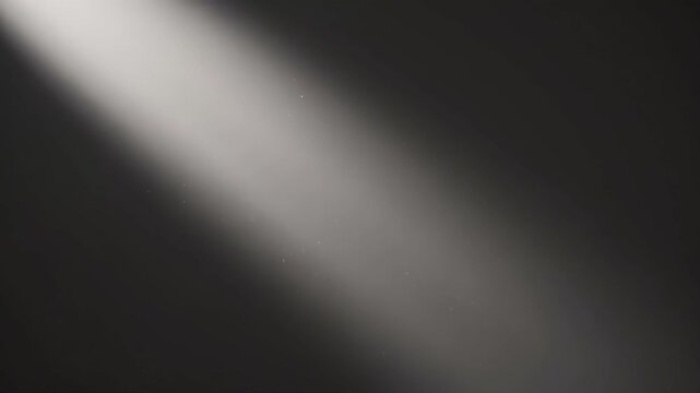 Floating dust particles suspended in a diagonal beam of light against a dark background. Atmospheric sunbeam shining through darkness with drifting specks. Cinematic overlay concept with copy space
