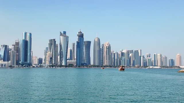 Stunning cinematic footage capturing the captivating skyline of Doha, Qatar, with a traditional dhow boat gracefully cruising on the turquoise waters of Doha Bay