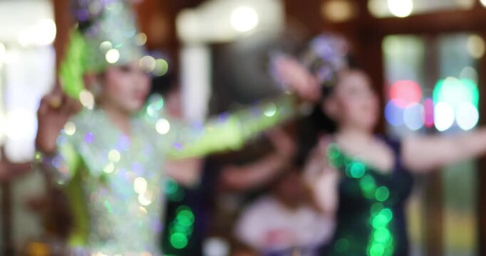Blurred Thai Likay dancers performing traditional dance on stage with colorful bokeh lights. Cultural performance representing Thai heritage, festival entertainment and nightlife