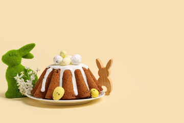 Naklejka premium Plate of sweet Easter bread with eggs, toy rabbit and beautiful flowers on yellow background