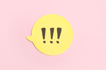 Fototapeta premium Yellow speech bubble with exclamation marks on pink background