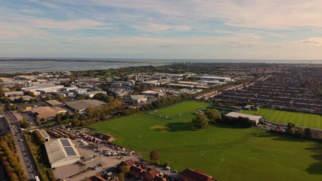 Portsmouth UK drone flight over commercial area close to the harbour green spaces and ack to back terraced housing with views out to sea on bright sunny day,detailed and varied aerial view