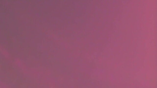 A vintage pink and purple grunge paper texture background featuring a light violet aged paint design on a textured canvas wall backdrop for a blank old material wallpaper