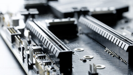 Two PCIe x16 expansion slots on a mainboard with electronic parts in soft focus. Technology background for GPU install, gaming rig, and computer engineering. Photo