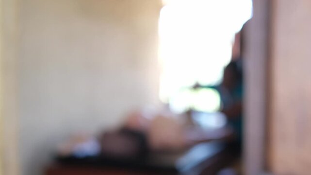 Blurred video of traditional full body Ayurvedic massage in Sri Lanka, out of focus spa treatment with professional masseuse and client in authentic wellness center, abstract bokeh background.