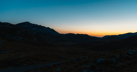 Obraz premium Grand panoramic view from Prutas peak at night with sky, overlooking the dramatic limestone ridges and deep valleys of Durmitor National Park, Montenegro.