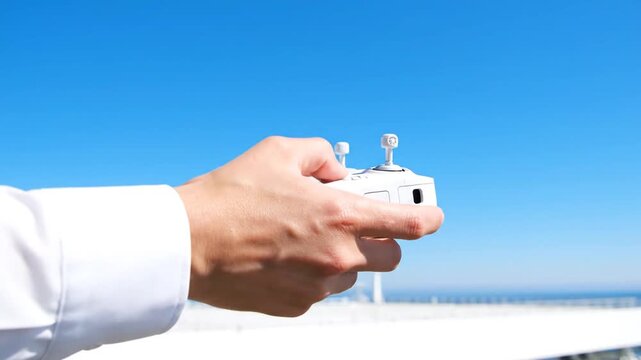 Person Holding Drone Controller Outdoors.