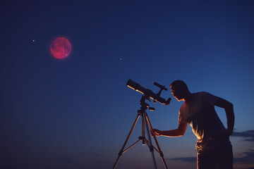 Fototapeta premium Amateur astronomer observing Lunar eclipse with a astronomical telescope.