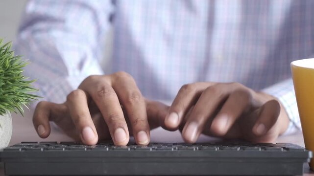 Close-up of hands typing on a keyboard, focusing on the motion of fingers