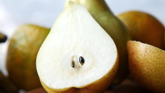 Macro view of fresh pears and oranges rotating slowly on wooden surface in cinematic light