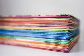Fototapeta premium pile of colorful children books on white desk with shallow depth of field