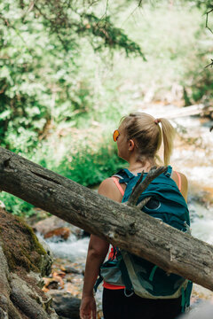 Woman hiking along Deer Creek Trail near stream in Bailey, Color