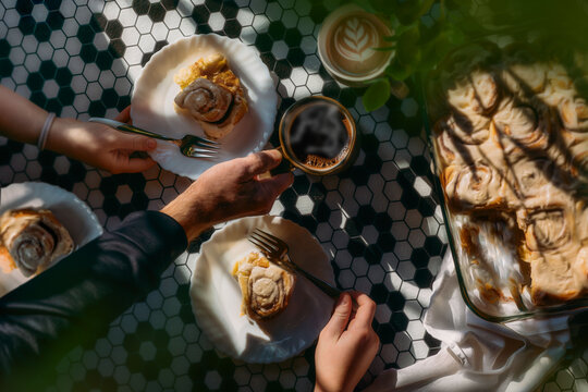 Hands Reaching for Cinnamon Roles and Coffee