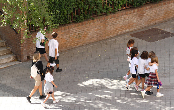 Ni&ntilde;os peque&ntilde;os de colegio infantil vuelta al cole escolar camino a clase a estudiar tras recreo en la calle