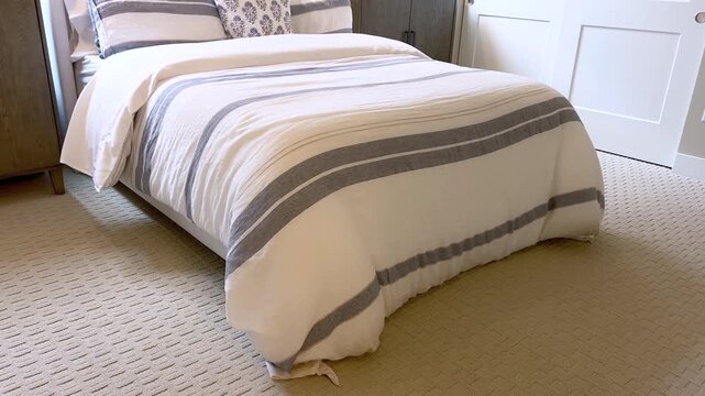 Cozy modern bedroom with striped bedding and natural light