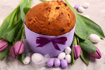 Delicious Easter cake with eggs and tulip flowers on beige background