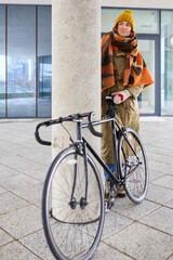 Fototapeta premium A female tourist rents a bicycle and explores the city in winter