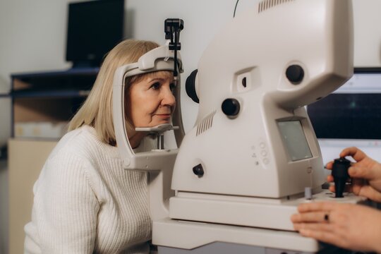 Senior woman undergoing autorefractor eye examination in clinic