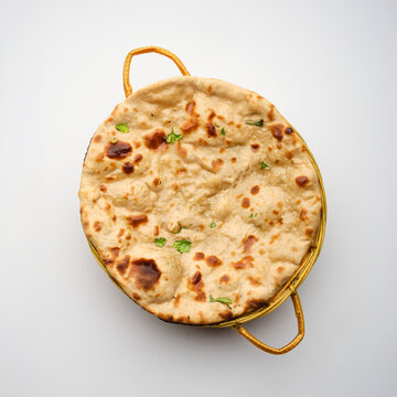 Flatbread is placed in a woven basket ready for serving during a meal in a kitchen setting