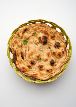 Freshly baked naan bread served in a round basket made of woven material