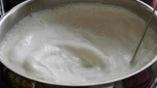 Slow Motion Stirring of Milk in Pot with Bubbles