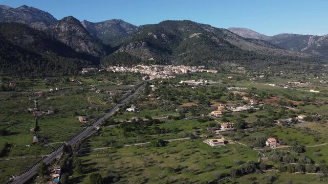 Aerial view of pastures with the town of Caimari and the Tramuntana mountain range in the background. Mallorca, Spain.