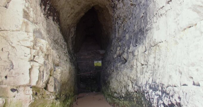 Tilting up shot of a cave in chalk cliffs at Kingsgate beach bay. At low tide.